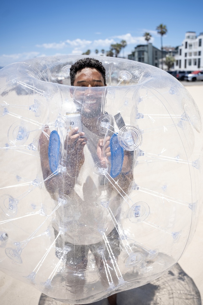 coworker in a bubble suit palyign bubble soccer on Venice Beach