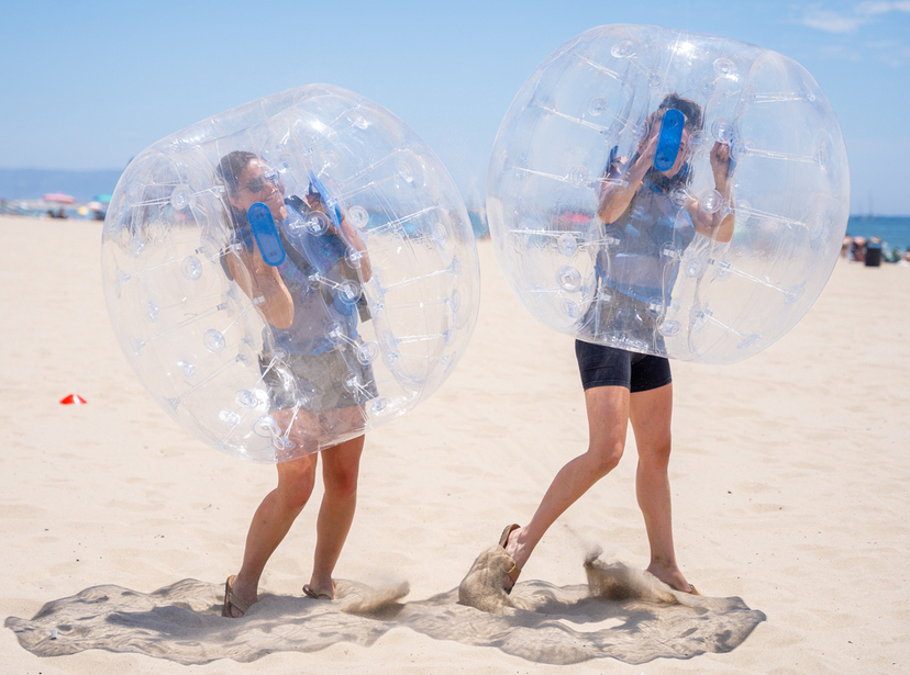 Orb Zorb ball rental game playing, 2 girl participants on Pacific Palisades beach